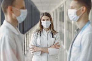COVID safety woman-in-white-coat-wearing-white-face-mask
