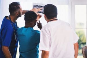 racism in healthcare three-person-looking-at-x-ray-result